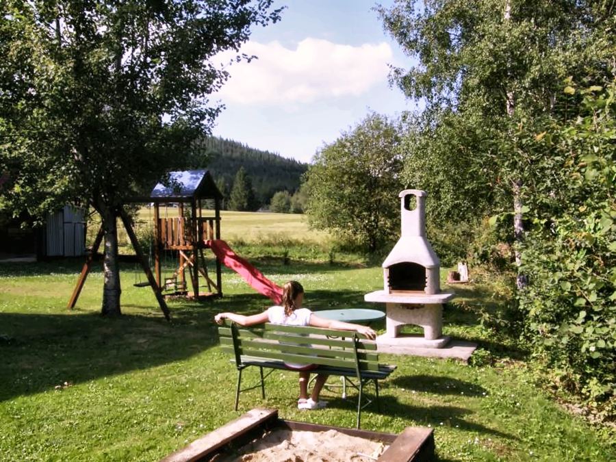 Zahrada s houpačkami, skluzavkou, pískovištěm a zděným grilem
