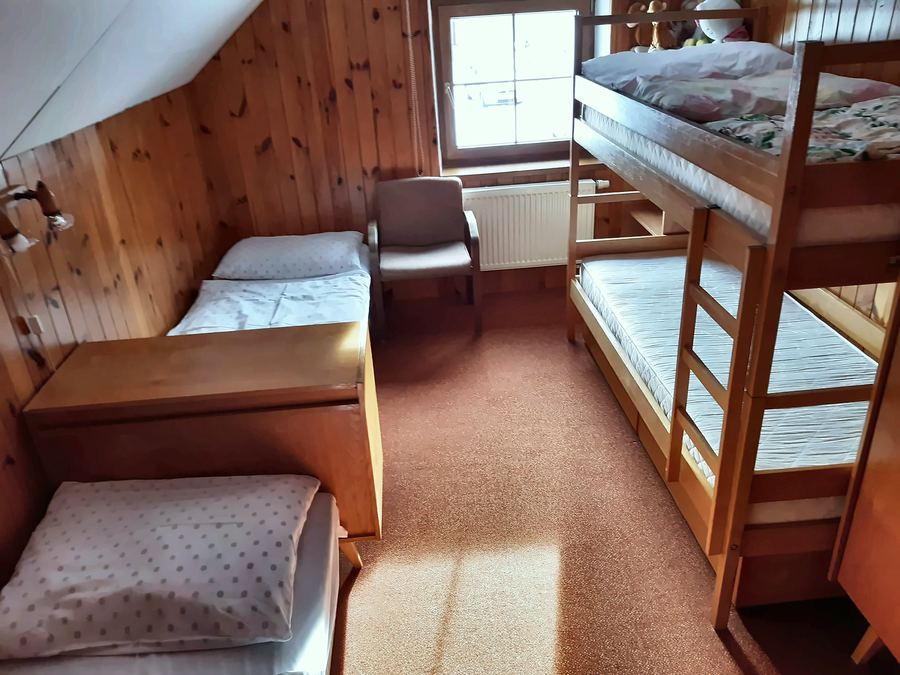 Pokoj obložený dřevem s palandou a dvěma lůžky
